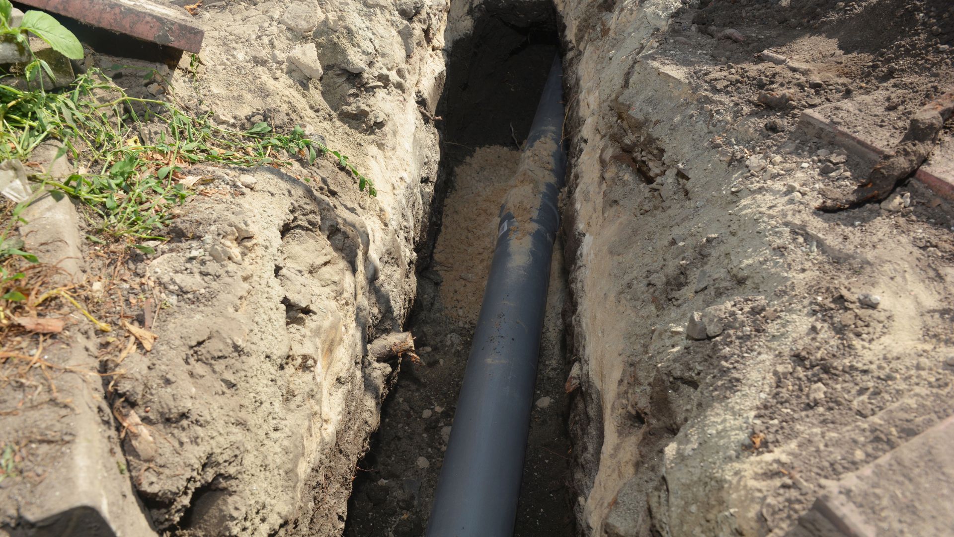 A pipe in the middle of a large hole in the ground