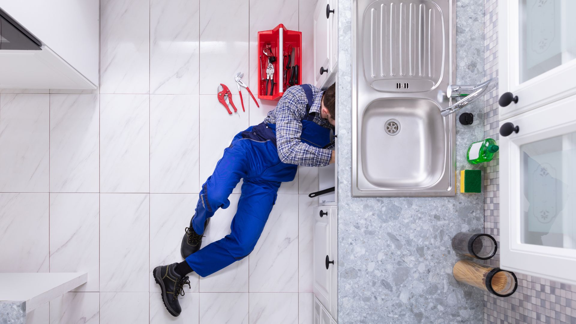 A man in blue overalls working on a wall