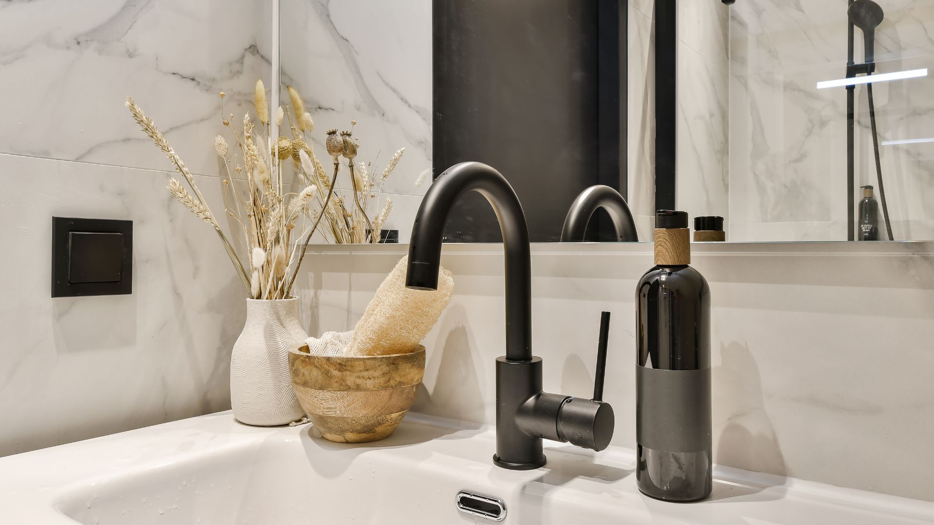 A bathroom sink with a soap dispenser and a bottle of wine